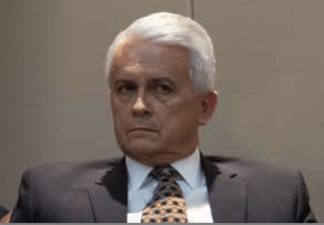 Clemente Sanchez in shadow wearing a suit